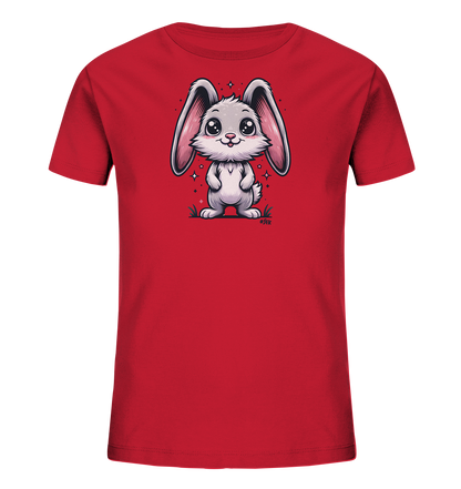 Onlineshop Shirts fuer Kinder - Das Bild zeigt ein leuchtend rotes Kinder-T-Shirt. Auf der Vorderseite ist eine Illustration eines suessen, cartoonhaften Hasen mit grossen Ohren abgebildet. Der Hase steht in einer Wiese, umgeben von funkelnden Sternen, und blickt freundlich nach vorne. Das Design wirkt verspielt und ansprechend fuer Kinder.