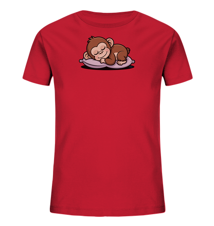 Onlineshop Shirts fuer Kinder - Das Bild zeigt ein rotes Kinder-T-Shirt. Auf der Vorderseite ist ein suesser, brauner Cartoon-Affe abgebildet, der friedlich auf einem lila Kissen schlaeft. Der Affe hat geschlossene Augen und einen entspannten Ausdruck. Das Design verleiht dem Shirt eine beruhigende und niedliche Ausstrahlung.