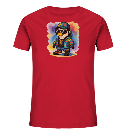Onlineshop Shirts fuer Kinder - Das Bild zeigt ein rotes Kinder-T-Shirt mit einem auffaelligen Motiv eines Pinguins. Der Pinguin traegt Sonnenbrille, Kopfhoerer, eine bunte Jacke und eine goldene Kette. Er steht auf einem gelblichen Untergrund vor einem farbenfrohen, aquarellartigen Hintergrund. Dieses Design verleiht dem Shirt einen verspielten und trendigen Look.