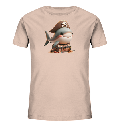 Onlineshop Shirts fuer Kinder - Das Bild zeigt ein helles Kinder T-Shirt mit einem froehlichen Motiv eines Cartoon-Hais. Der Hai traegt einen Piratenhut mit Totenkopf und sitzt auf einer hoelzernen Schatzkiste. Um die Kiste herum liegen Muscheln und Sand, was eine maritime Szene darstellt. Das Design ist detailreich und farbenfroh.
