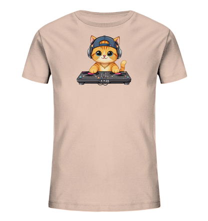 Onlineshop Shirts fuer Kinder - Das Bild zeigt ein hellrosafarbenes T-Shirt mit einer charmanten Cartoon-Katzenillustration auf der Vorderseite. Die Katze traegt Kopfhoerer und eine Muetze und sitzt hinter einem DJ-Mischpult mit zwei Plattenspielern. Das Design wirkt verspielt und musikalisch, mit leuchtenden Farben und freundlichem Ausdruck der Katze.