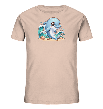 Onlineshop Shirts fuer Kinder - Das Bild zeigt ein hellrosa T-Shirt mit einem niedlichen Cartoon-Delfinmotiv auf der Vorderseite. Ein blauer Delfin sitzt auf einem sandigen Untergrund, umgeben von stilisierten Wellen und Muscheln. Die Darstellung des Delfins ist freundlich und farbenfroh gestaltet, was dem Shirt einen froehlichen Charakter verleiht.