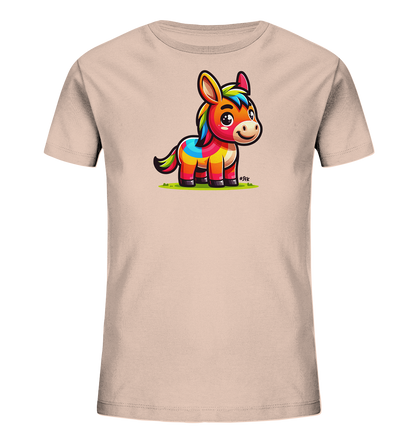Onlineshop Shirts fuer Kinder - Das Bild zeigt ein Kinder-T-Shirt in einem hellen Beigeton. Auf der Vorderseite ist eine bunte, cartoonhafte Abbildung eines Esels oder Ponys zu sehen. Das Tier hat eine regenbogenfarbene Maehne und Koerperzeichnung und steht auf gruenem Gras. Die Grafik ist lebendig und farbenfroh.