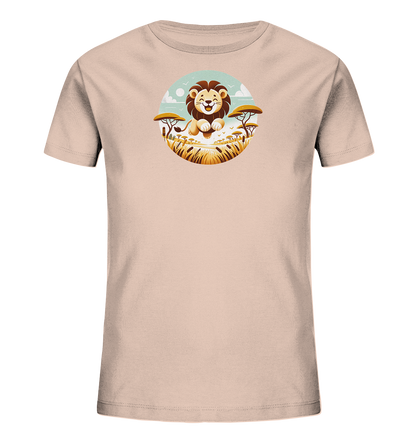 Onlineshop Shirts fuer Kinder - Das Bild zeigt ein hellrosa Kinder-T-Shirt mit einer runden Grafik eines laechelnden Loewen in einer Savannenlandschaft. Die Szene umfasst hohes Gras, Akazienbaeume und Voegel unter einem blauen Himmel. Der freundliche, cartoonartige Loewe sitzt im Vordergrund. Dieses Design ist ideal fuer junge Tierliebhaber.