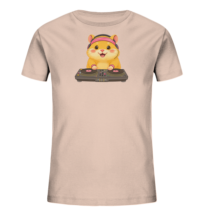 Onlineshop Shirts fuer Kinder - Das Bild zeigt ein hellbeiges Kinder-T-Shirt, das mit einem froehlichen Cartoon-Hamster bedruckt ist. Der Hamster traegt pinke Kopfhoerer und steht laechelnd an einem DJ-Mischpult. Die Pfoten sind auf den Plattentellern positioniert, was eine spielerische Szene kreiert. Dieses Design verleiht dem Shirt einen verspielten und musikalischen Charakter.