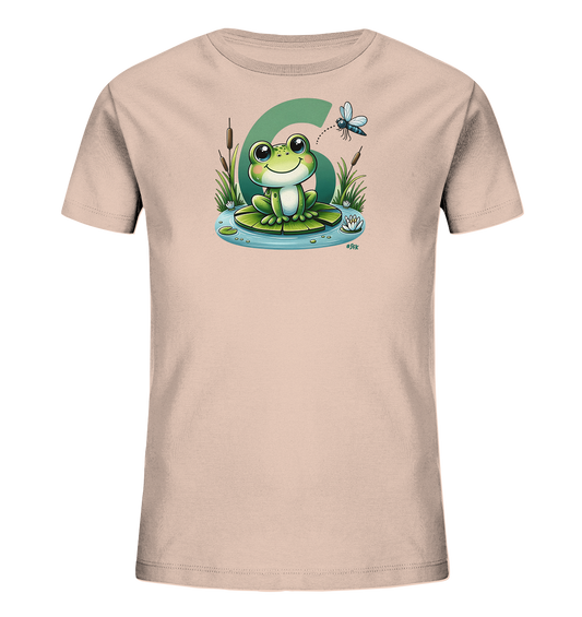 Onlineshop Shirts fuer Kinder - Das Bild zeigt ein hellrosa T-Shirt mit einer suessen Illustration eines Frosches. Der Frosch sitzt auf einem Seerosenblatt in einer Teichszene mit Wasserpflanzen und Blueten. Eine Libelle fliegt ueber dem Frosch. Eine grosse gruene Zahl '6' ist prominent hinter der Teichgrafik abgebildet.