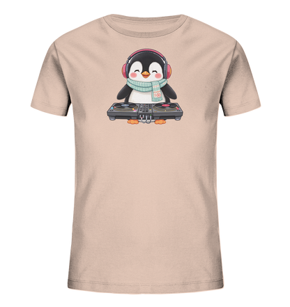 Onlineshop Shirts fuer Kinder - Das Bild zeigt ein hellbeiges Kinder-T-Shirt mit einem niedlichen Cartoon-Pinguin als Motiv. Der Pinguin traegt rote Kopfhoerer und einen gemusterten hellblauen Schal. Vor ihm steht ein detailliert dargestelltes DJ-Mischpult mit Plattenspielern. Das Design wirkt froehlich und verspielt.