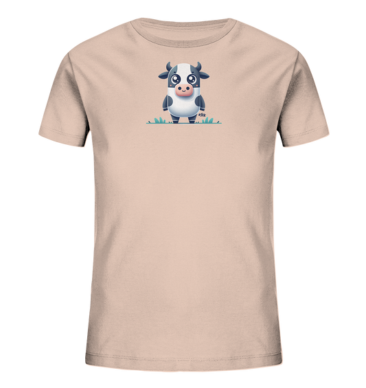 Onlineshop Shirts fuer Kinder - Das Bild zeigt ein T-Shirt fuer Kinder in einem hellen Beigeton. Auf der Vorderseite ist eine Illustration einer Kuh im Cartoon-Stil zu sehen. Die Kuh ist schwarz-weiss gefleckt und steht in einer Darstellung von gruenem Gras. Sie hat grosse, runde Augen und blickt geradeaus.
