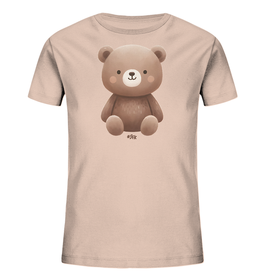 Onlineshop Shirts fuer Kinder - Das Bild zeigt ein hellrosa T-Shirt mit einem zentralen Druckmotiv. Dargestellt ist ein niedlicher brauner Cartoon-Baer, der aufrecht sitzt. Der Baer hat ein freundliches Gesicht mit rosafarbenen Wangen. Das Design ist schlicht und ansprechend fuer Kinder.