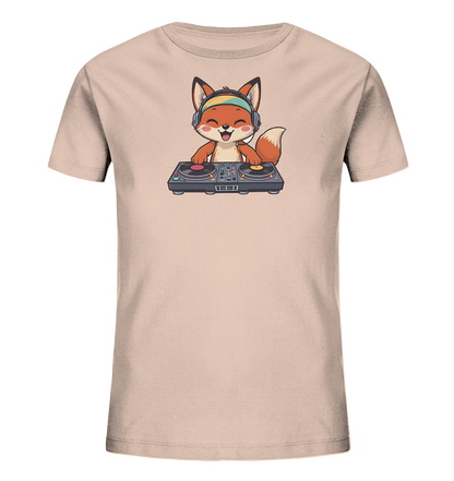 Onlineshop Shirts fuer Kinder - Das Bild zeigt ein hellbeiges Kinder-T-Shirt mit einem niedlichen Fuchs-Motiv auf der Vorderseite. Der Cartoon-Fuchs traegt bunte Kopfhoerer und sitzt an einem DJ-Mischpult, das zwei Plattenspieler und einen Mixer umfasst. Er hat einen froehlichen Gesichtsausdruck mit herausgestreckter Zunge, was dem Design eine spielerische Note verleiht.