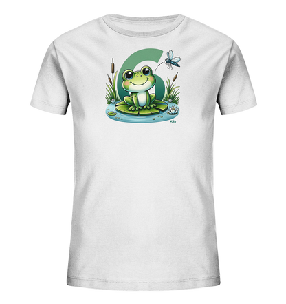 Onlineshop Shirts fuer Kinder - Das Bild zeigt ein weisses T-Shirt mit einer niedlichen Illustration eines freundlichen Frosches. Der Frosch sitzt auf einem Seerosenblatt in einem Teich, umgeben von Schilf und Seerosen. Hinter dem Frosch ist eine grosse gruene Zahl '6' abgebildet. Eine kleine Libelle fliegt ueber dem Frosch und ergaenzt das verspielte Motiv.