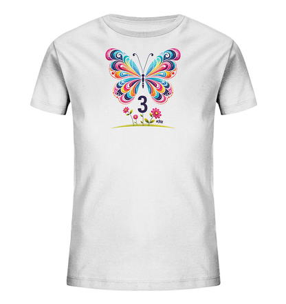 Onlineshop Shirts fuer Kinder - Dieses weisse Kinder-T-Shirt zeigt ein farbenfrohes Motiv mit einem grossen, detailreichen Schmetterling. Darunter ist die Zahl '3' in dunkler Farbe platziert. Kleine rosa Blumen und gruenes Gras runden das froehliche Design ab.