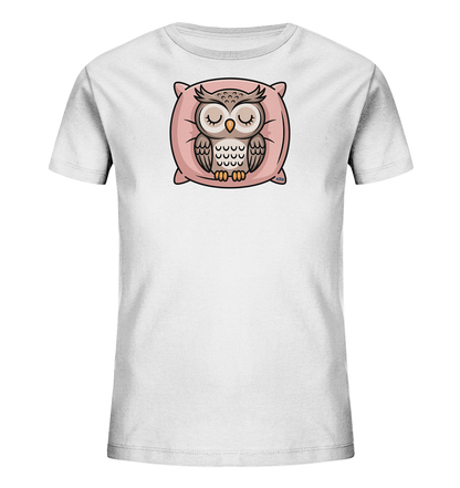Onlineshop Shirts fuer Kinder - Das Bild zeigt ein weisses Kinder-T-Shirt mit einem niedlichen Aufdruck einer schlafenden Eule. Die Eule sitzt friedlich auf einem weichen, rosafarbenen Kissen, ihre Augen sind geschlossen. Ihr Gefieder ist in verschiedenen Braun- und Beigetoenen dargestellt. Das verspielte Design verleiht dem T-Shirt einen beruhigenden und liebevollen Charakter.