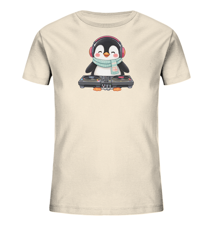 Onlineshop Shirts fuer Kinder - Das Bild zeigt ein hellbeiges Kinder-T-Shirt mit einem niedlichen Cartoon-Pinguin als Motiv. Der Pinguin traegt rote Kopfhoerer und einen hellblauen Schal mit Muster, waehrend er vor einem DJ-Mischpult steht. Er hat einen froehlichen Gesichtsausdruck mit geschlossenen Augen und einem Laecheln. Das Design verleiht dem Shirt einen spielerischen und musikalischen Charakter.