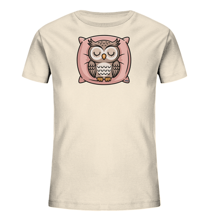 Onlineshop Shirts fuer Kinder - Das Bild zeigt ein hellbeiges Kinder-T-Shirt. Auf der Vorderseite ist eine schlafende Eule dargestellt, die friedlich auf einem rosa Kissen liegt. Die Eule hat geschlossene Augen und ist in natuerlichen Braun- und Grautoenen gehalten. Das gesamte Motiv strahlt Ruhe aus und ist ideal fuer kleine Traeumer.
