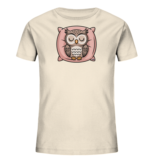 Onlineshop Shirts fuer Kinder - Das Bild zeigt ein hellbeiges Kinder-T-Shirt. Auf der Vorderseite ist eine schlafende Eule dargestellt, die friedlich auf einem rosa Kissen liegt. Die Eule hat geschlossene Augen und ist in natuerlichen Braun- und Grautoenen gehalten. Das gesamte Motiv strahlt Ruhe aus und ist ideal fuer kleine Traeumer.