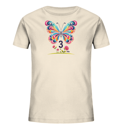 Onlineshop Shirts fuer Kinder - Das Bild zeigt ein cremefarbenes Kinder T-Shirt. Auf der Vorderseite ist eine grosse, farbenfrohe Schmetterlingsgrafik mit verschiedenen Mustern. Unterhalb des Schmetterlings ist die dunkle Zahl "3" platziert. Darunter befinden sich zwei rosa Blumen mit gruenen Staengeln, die auf einer Grasflaeche stehen.