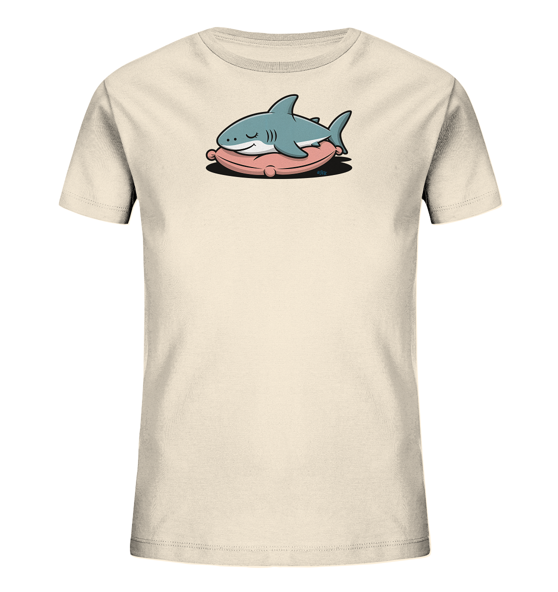 Onlineshop Shirts fuer Kinder - Das Bild zeigt ein hellbeiges Kinder-T-Shirt. Auf der Vorderseite ist ein niedlicher, blauer Cartoon-Hai abgebildet, der entspannt auf einem rosa Kissen liegt. Der Hai hat geschlossene Augen und einen kleinen, freundlichen Gesichtsausdruck. Das Design wirkt ruhig und verspielt.