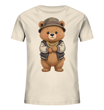 Onlineshop Shirts fuer Kinder - Das cremefarbene Kinder-T-Shirt zeigt ein niedliches Baerenmotiv auf der Vorderseite. Der Baer traegt eine Bomberjacke mit hellen Ärmeln, eine goldene Kette und einen Fischerhut. Er hat ein freundliches Gesicht und die Pfoten vor dem Koerper verschraenkt. Das verspielte Design verleiht dem T-Shirt einen modernen und coolen Look.