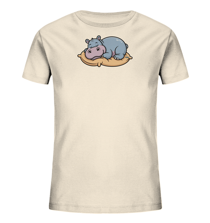 Onlineshop Shirts fuer Kinder - Das Bild zeigt ein hellbeiges Kinder-T-Shirt mit einem niedlichen Tiermotiv auf der Vorderseite. Ein graublaues Nilpferd ist darauf zu sehen, wie es schlafend auf einem beigen Kissen liegt. Das Nilpferd hat geschlossene Augen und vermittelt einen entspannten Eindruck. Das gesamte Motiv wirkt freundlich und friedlich.