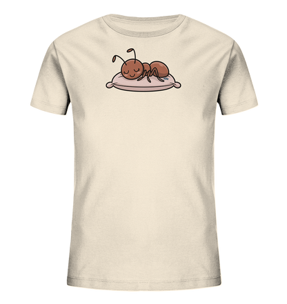 Onlineshop Shirts fuer Kinder - Das Bild zeigt ein hellbeiges Kinder-T-Shirt mit einem niedlichen Aufdruck. Darauf ist eine braune, cartoonhafte Ameise zu sehen, die friedlich auf einem rosa Kissen schlaeft. Die Ameise hat geschlossene Augen und wirkt sehr entspannt. Das Design verleiht dem Shirt einen ruhigen und verspielten Charakter.
