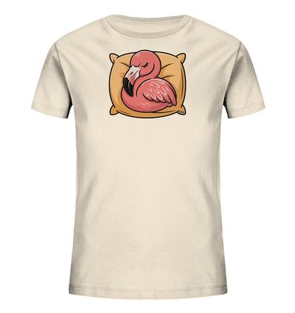 Onlineshop Shirts fuer Kinder - Das Bild zeigt ein hellbeiges Kinder-T-Shirt mit einem niedlichen Aufdruck. Ein rosa Flamingo ruht friedlich auf einem beigen Kissen, die Augen geschlossen. Das verspielte Design wirkt beruhigend und ist ideal fuer kleine Traeumer. Es verleiht dem Shirt einen sanften und kinderfreundlichen Charakter.
