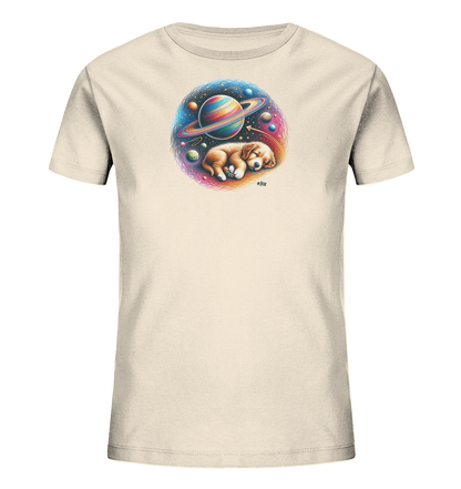 Onlineshop Shirts fuer Kinder - Dieses Bild zeigt ein cremefarbenes Kinder-T-Shirt mit einem grossen, runden Aufdruck auf der Vorderseite. Der Aufdruck zeigt einen schlafenden Welpen in einem fantastischen Weltraumsetting. Man sieht einen bunten Planeten mit Ringen, umgeben von weiteren Himmelskoerpern und Sternen. Das Design wirkt vertraeumt und farbenfroh.
