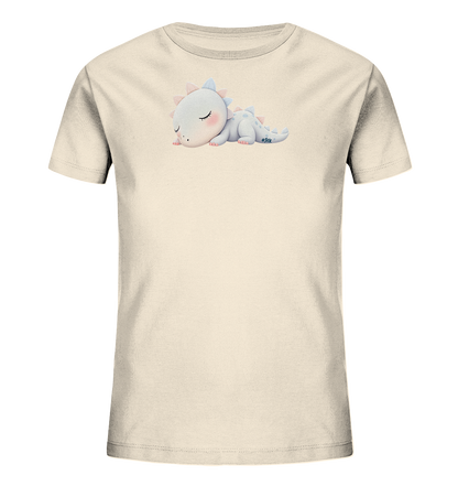 Onlineshop Shirts fuer Kinder - Das Bild zeigt ein beiges Kinder-T-Shirt mit einem niedlichen Motiv eines schlafenden Baby-Drachen auf der Vorderseite. Der kleine Drache ist hellblau-grau gefaerbt, hat rosafarbene Wangen und Stacheln und liegt friedlich mit geschlossenen Augen da. Das Design ist zentral platziert und verleiht dem Shirt einen sanften und beruhigenden Ausdruck.