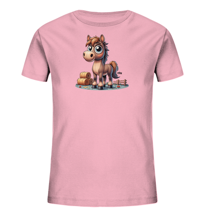 Onlineshop Shirts fuer Kinder - Das rosa T-Shirt fuer Kinder zeigt eine charmante Cartoon-Illustration eines Pferdes. Das Pferd steht in einer laendlichen Szene mit Heuballen und einem Holzzaun im Hintergrund. Kleine rote Objekte und gruene Graeser ergaenzen das Motiv am Boden, was dem Design eine froehliche Note verleiht.