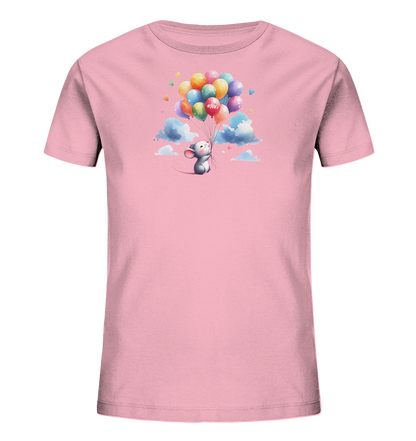 Onlineshop Shirts für Kinder - Das Bild zeigt ein rosa Kinder-T-Shirt mit einem farbenfrohen Motiv. Eine kleine graue Maus schwebt, festgehalten an einer Gruppe bunter Luftballons, über einigen Wolken. Einige der Ballons sind in Herzform, und auf einem roten Ballon steht "#SFK.". Das Design wirkt verspielt und leicht.