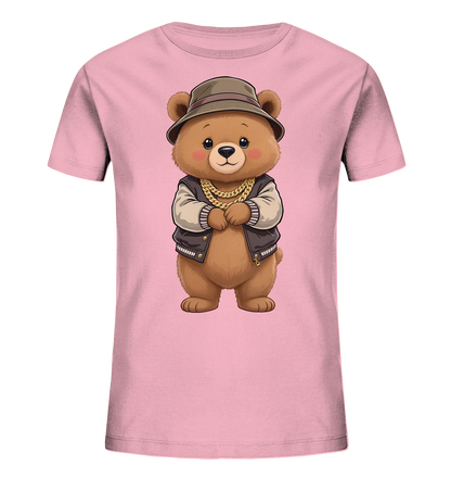 Onlineshop Shirts fuer Kinder - Das Bild zeigt ein hellrosa Kinder-T-Shirt. Auf der Vorderseite ist ein niedlicher Teddybaer mit einem freundlichen Ausdruck abgebildet. Er traegt eine dunkle Bomberjacke, einen Hut und eine goldene Kette. Das Motiv verleiht dem Shirt einen laessigen und coolen Charakter.