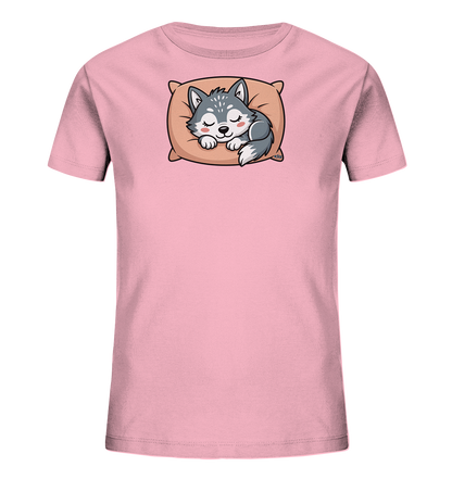 Onlineshop Shirts fuer Kinder - Das Bild zeigt ein hellrosa Kinder-T-Shirt mit einem niedlichen Aufdruck auf der Vorderseite. Darauf ist ein kleiner, schlafender Husky-Welpe zu sehen, der gemuetlich auf einem beigefarbenen Kissen liegt. Der Welpe hat graues Fell und weisse Akzente, seine Augen sind geschlossen und die Wangen rosig. Das Design verleiht dem T-Shirt einen friedlichen und herzerwaermenden Charakter.