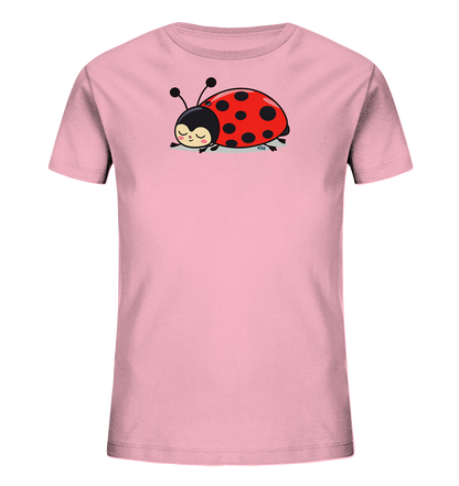 Onlineshop Shirts fuer Kinder - Das Bild zeigt ein hellrosa Kinder-T-Shirt. Auf der Vorderseite befindet sich eine reizende Illustration eines roten Marienkaefers mit schwarzen Punkten, der schlafend oder ruhend dargestellt ist. Der Marienkaefer hat einen schwarzen Kopf, Fuehler und geschlossene, zufriedene Augen. Dieses Design verleiht dem Shirt einen ruhigen und suessen Charakter.