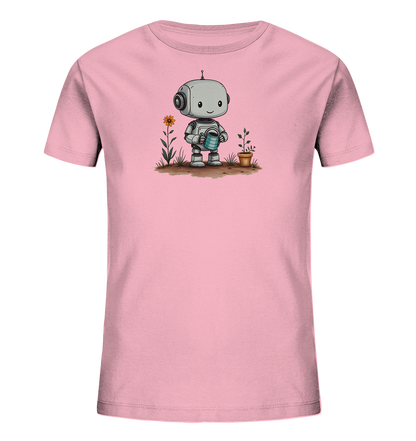 Onlineshop Shirts für Kinder - Das Bild zeigt ein rosa T-Shirt für Kinder mit einem niedlichen Aufdruck auf der Vorderseite. Der Aufdruck zeigt einen freundlichen, grauen Roboter, der eine blaue Gießkanne hält. Neben dem Roboter wachsen eine orangefarbene Blume und eine kleine Pflanze in einem Topf, was die Szene eines Roboters beim Gärtnern darstellt. Dieses Design verleiht dem Shirt einen verspielten und naturverbundenen Touch, der Kinder ansprechen dürfte.