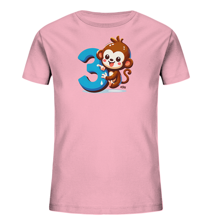 Onlineshop Shirts fuer Kinder - Das Bild zeigt ein hellrosafarbenes T-Shirt fuer Kinder. Auf der Vorderseite ist ein suesser Cartoon-Affe abgebildet, der neben einer grossen, blauen Zahl '3' sitzt. Der Affe laechelt und hat eine verspielte Haltung. Dieses Design ist farbenfroh und ansprechend fuer kleine Kinder.