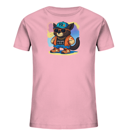 Onlineshop Shirts fuer Kinder - Das Bild zeigt ein rosafarbenes Kinder-T-Shirt mit einem coolen Katzenmotiv auf der Vorderseite. Die Katze traegt eine blaue Kappe, Sonnenbrille, eine orange Jacke, Jeans und eine goldene Kette mit Boombox-Anhaenger. Im Hintergrund sind bunte Farbspritzer in Blau, Lila und Gelb zu sehen. Das gesamte Design wirkt verspielt und modern.