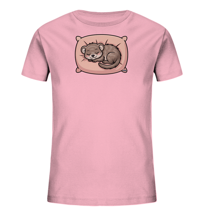 Onlineshop Shirts fuer Kinder - Das Bild zeigt ein rosafarbenes Kinder-T-Shirt. Auf der Vorderseite ist eine Illustration eines schlafenden Otters abgebildet. Der Otter liegt friedlich auf einem hellbraunen Kissen und ist zusammengerollt. Das Design wirkt sehr niedlich und beruhigend.